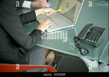 Business people with laptop showing bar chart Stock Photo