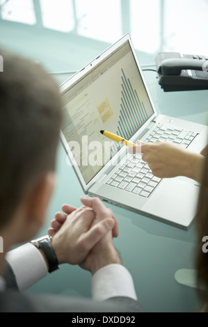 Business people with laptop showing bar chart Stock Photo