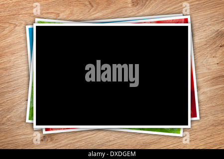 Stack of printed pictures collage on wooden table with copy space for your photo Stock Photo