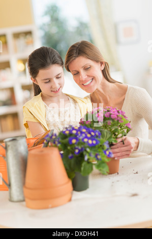 Girl (8-9) and mother potting flowers