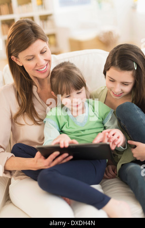 Mother and daughters (4-5,8-9) using tablet pc Stock Photo
