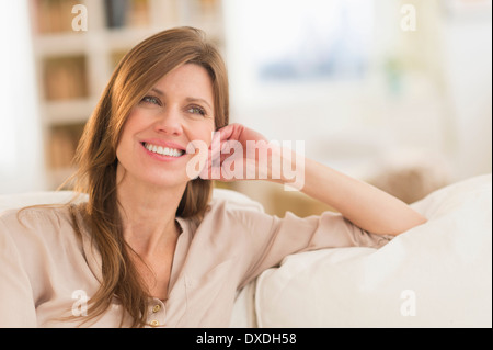 Portrait of woman sitting on sofa Stock Photo