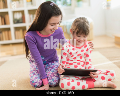 Two sisters (4-5,8-9) using tablet pc Stock Photo