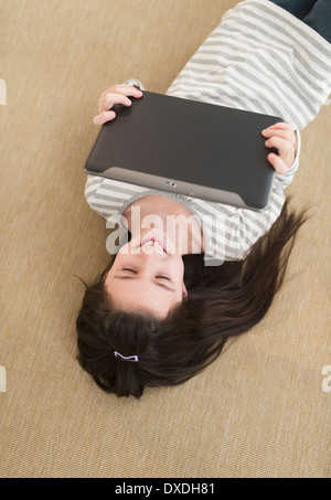Girl (8-9) lying on floor using tablet pc Stock Photo