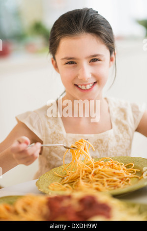 Portrait of girl (8-9) eating pasta Stock Photo