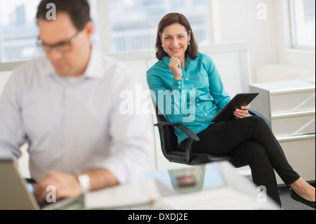 Businessman and businesswoman working in office Stock Photo