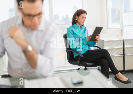 Businessman and businesswoman working in office Stock Photo