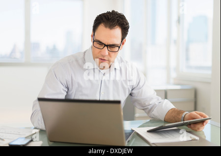 Businessman using laptop and digital tablet Stock Photo
