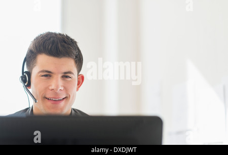 Young man sitting in front of desk and talking Stock Photo