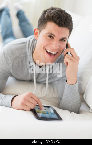 Young man using tablet and talking by phone Stock Photo