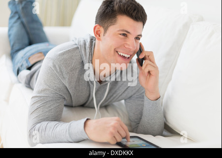 Young man using tablet and talking by phone Stock Photo