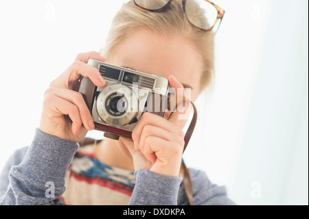 Woman looking through vintage camera Stock Photo