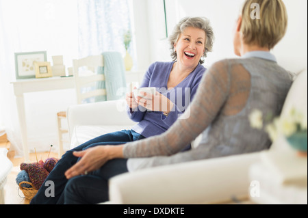Two women sitting on coach talking Stock Photo