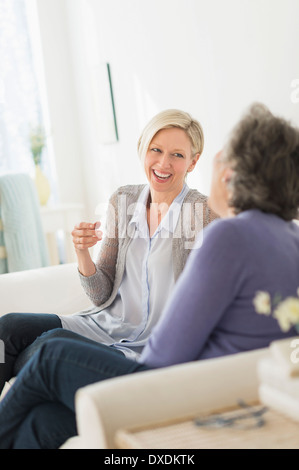 Two women sitting on coach talking Stock Photo