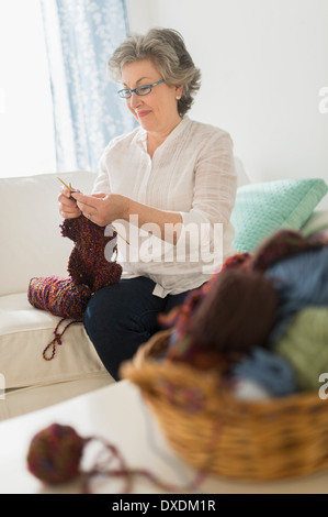 Mature Woman Sitting On Sofa Watching Television At Home Stock Photo ...