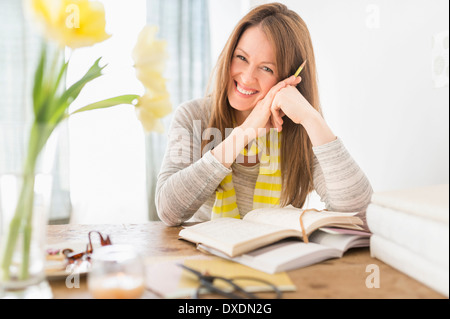 Portrait of smiling woman sitting at desk Stock Photo