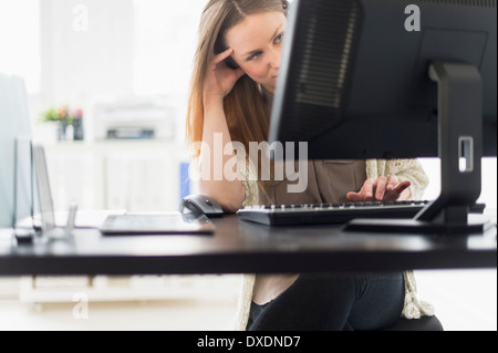 Portrait of young woman working on computer in office Stock Photo