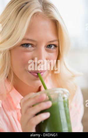 Portrait of young woman drinking smoothie Stock Photo