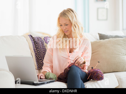 Portrait of young woman learning knitting Stock Photo