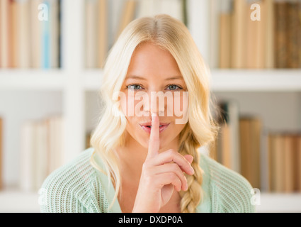 Portrait of woman with finger on lips Stock Photo