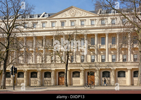 Winter trees in front of Part of Carlton House Terrace façade with colonnade seen from The Mall in St James Park London England UK Stock Photo