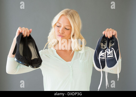 Portrait of young woman holding shoes Stock Photo
