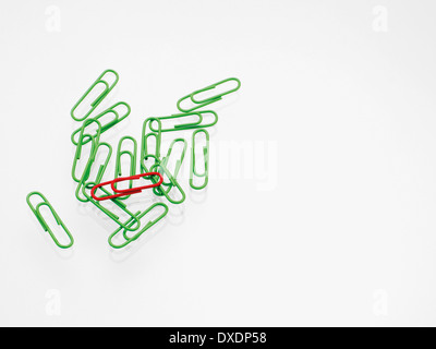 Green and red paper clips on white background, studio shot Stock Photo