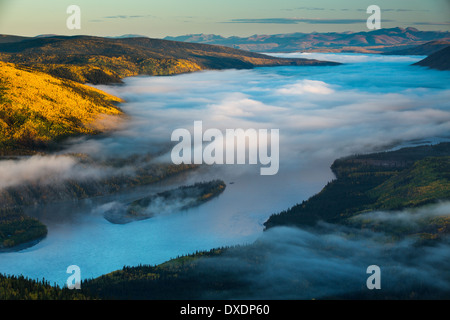 Mist in the valley of the Yukon River at dawn, downstream of Dawson City from Dome Hill, Yukon Territories, Canada Stock Photo