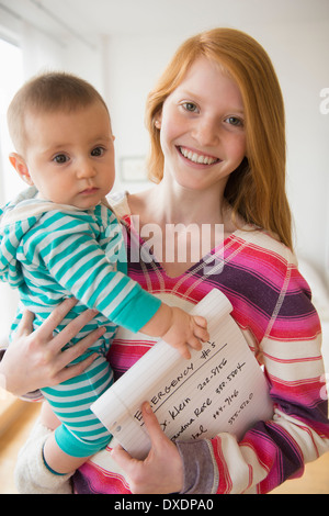 Portrait of girl (12-13) with baby girl (12-13) (2-5 months) Stock Photo