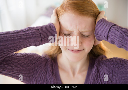 Front view of girl (12-13) with head on head Stock Photo