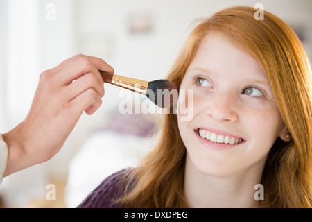 Portrait of girl (12-13) getting make-up Stock Photo