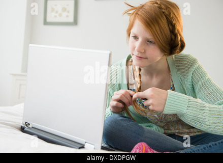 Girl (12-13) using laptop Stock Photo