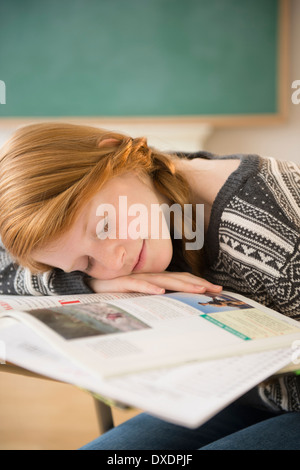 Girl (12-13) sleeping on desk Stock Photo