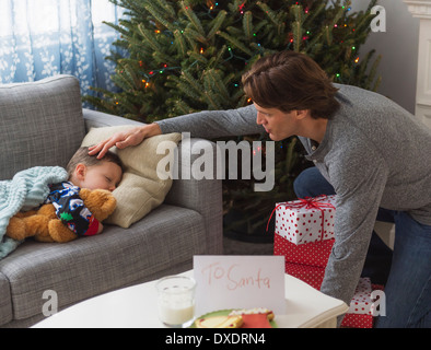 Father looking after boy (6-7) during sleep Stock Photo