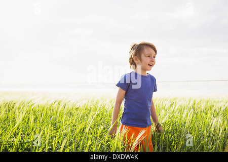 Boy (4-5) standing in grass and looking away, Barley, Colorado, USA Stock Photo