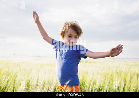 Boy (4-5) standing in grass with raised arms, Barley, Colorado, USA Stock Photo