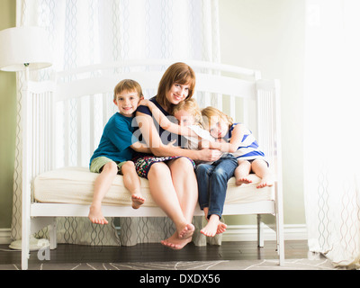 Mother embracing son (8-9) and daughters (4-5, 6-7) Stock Photo