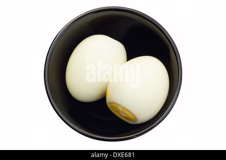 two boiled eggs in black bowl in white background Stock Photo