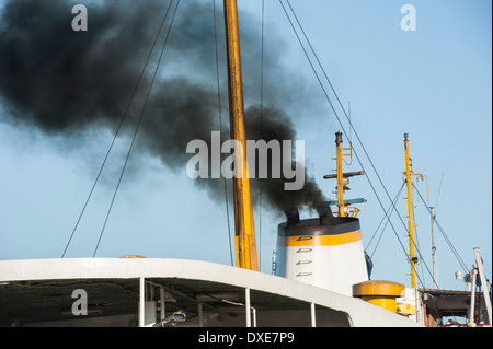 Black exhaust smoke coming from ship smoke stack funnel air pollution concept Stock Photo