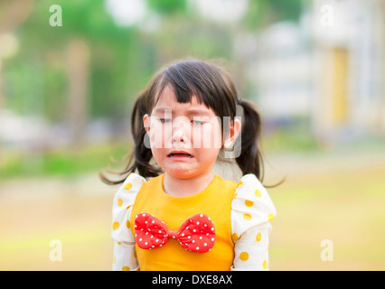 cute and crying little girl in the park Stock Photo