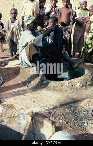 Kano, Nigeria. Dyer Dying Cloth in the Indigo Dying Pits of Kano