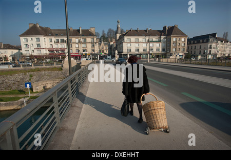 Chateau-Thierry, France. March 2014 Woman wheels her shopping basket across bridge in Chateau-Thierry Stock Photo