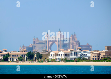 Luxury villas on frond of Palm Island man-made island with Atlantis the Palm hotel to rear in Dubai United Arab Emirates Stock Photo