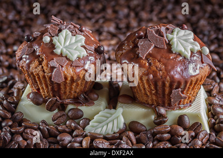 Chocolate muffins on the background of coffee beans. Stock Photo