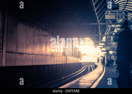 Dark train station and light at the end. Toned grainy 35mm film scan. Stock Photo