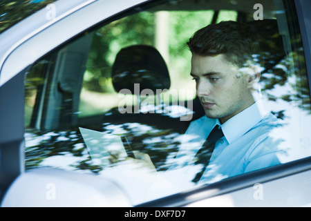 Businessman working on Tablet Computer in Car, Mannheim, Baden-Wurttemberg, Germany Stock Photo