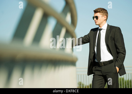 Portrait of businessman standing by railing and looking at view, Germany