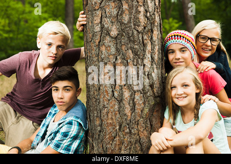 Portrait of group of children posing next to tree in park, Germany Stock Photo