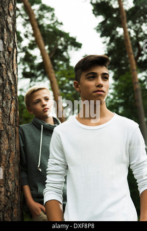Portrait of two boys standing next to tree in park, Germany Stock Photo