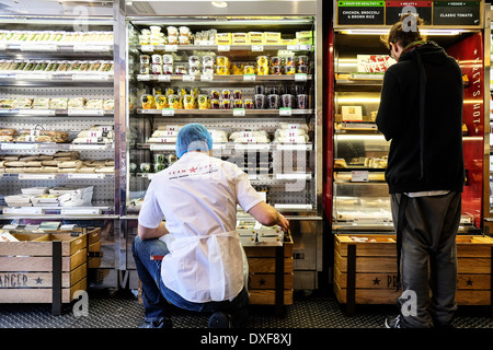 A member of the Pret a Manger staff stocking shelves. Stock Photo